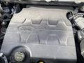 A close-up view of a 2017 Ford Edge engine cover displaying the Ford logo and a yellow oil cap