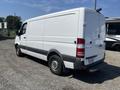 A white 2016 Mercedes-Benz Sprinter van with smooth sides and rear doors is shown parked in a gravel area