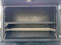 An empty cargo space with two shelves built into the interior of a 2015 Ford F-550 truck