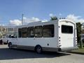 A 2017 Chevrolet Express bus with a white exterior and large windows is parked with its rear visible