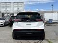 A white 2023 Chevrolet Bolt EV seen from the rear with a black roof and distinctive taillights
