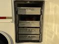A storage compartment with four metal drawers, partially open, revealing various items inside. The compartment is part of a 2010 Ford F-550 vehicle