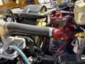Close-up of a 2011 Freightliner B2 engine showcasing hoses and components including a red intake pipe and various connecting lines