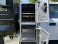 A 2019 Ford F-550 featuring open compartments with diamond plate doors showcasing empty storage space inside