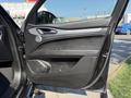 The interior door panel of a 2020 Alfa Romeo Stelvio featuring black upholstery a silver door handle and controls for windows and locks