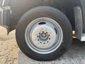 A close-up of a silver wheel and tire on a 2009 Ford F-550 with visible lug nuts and tire tread detail