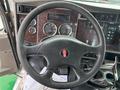 Steering wheel and dashboard of a 2013 Kenworth T370 displaying gauges and controls