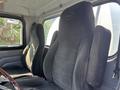 Two black plush seats inside a 2008 Peterbilt 340 truck cabin with a steering wheel visible in the foreground