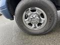 A close-up of a chrome wheel and tire from a 2006 Dodge Ram 2500 featuring the Ram logo in the center