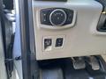A 2015 Ford F-150 control panel featuring various buttons including a circular dial and a pull switch for adjusting vehicle settings