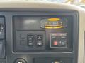 Dashboard of a 2012 International DuraStar 4300 featuring various control buttons and a gauge labeled DRIVER CONTROL with directional indicators