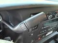 A control lever in a 2015 GMC Savana with buttons for adjusting settings and features, located on the dashboard near the audio controls
