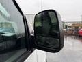 Close-up of the side mirror of a 2021 Chevrolet Express with raindrops on the surface