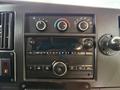 Dashboard controls of a 2019 Chevrolet Express featuring climate control knobs a radio display and various audio buttons