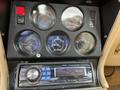 Dashboard of a 1970 Chevrolet Corvette featuring gauges for fuel, water temperature, oil pressure, battery and a car radio with volume and tuning controls