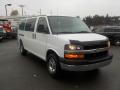 A white 2011 Chevrolet Express van with a black grille and headlights parked at an angle with its front facing forward