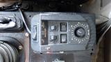 Control panel of a 2003 International 5600i featuring various buttons and a dial for operating vehicle functions