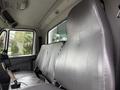 Interior view of a 2012 International TerraStar showcasing a driver's seat and a passenger seat with gray upholstery and a gear shift lever visible