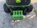 A 2021 John Deere 1575 lawn mower showing the rear weight bar with four green weights attached