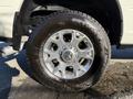 A close-up of a 2023 RAM 3500 wheel showing a chrome rim with multiple spokes and a rugged tire tread design