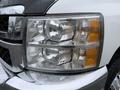 Close-up of the headlights of a 2013 Chevrolet Silverado 3500HD showing clear and amber lights with raindrops on the surface