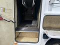 Interior view of a 2015 Ford F-550 with a spacious cargo area featuring a rubberized floor and metal hanging hooks on the side
