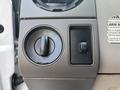 A control panel from a 2009 Ford F-550 featuring a switch for lighting and a dial for adjusting settings