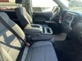 Interior view of a 2015 Chevrolet Silverado 1500 showing front seats and center console with cup holders and storage compartment
