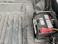 A black car battery with a red terminal connector is situated on the floor of a 1968 Ford Mustang Two Door Convertible