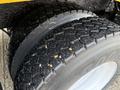 Close-up of two treaded tires on a 2016 International 7400 showing signs of wear and small debris embedded in the tire grooves
