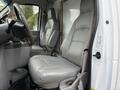Interior of a 2019 Ford Econoline showing two gray leather seats and the driver's side dashboard with steering wheel and console