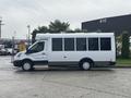 A white 2021 Ford Transit-350 van with a long body and large windows parked on a lot