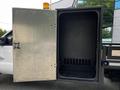 The image shows the open compartment of a 2016 Ford F-550 revealing a spacious interior with a smooth black surface and vertical slots along the back wall for storage