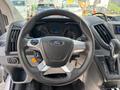Steering wheel and dashboard of a 2018 Ford Transit-350 with controls and a digital display visible in the center