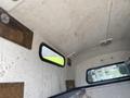 Interior view of a 2014 Ford F-350 SD with a simple, white ceiling and wooden panels on the walls