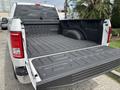 A 2017 Ford F-150 with its tailgate down showing a textured truck bed liner and a spacious cargo area
