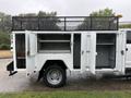 A 2020 Ford F-550 with an open service body featuring multiple compartments and a ladder rack on top