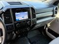 The interior of a 2019 Ford F-550 featuring a modern dashboard multimedia system with a touchscreen display and various control knobs