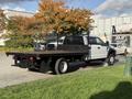 A 2019 Ford F-550 flatbed truck with a black bed and white cabin positioned at an angle