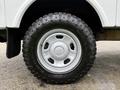 A silver wheel with a black off-road tire mounted on a 2015 Ford F-350 SD