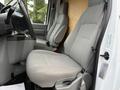 Interior view of a 2019 Ford Econoline showing two gray cloth seats with a center console between them