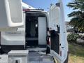 A 2019 Ford Transit 350 with open rear doors revealing a spacious cargo area and interior features visible inside