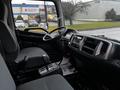 Interior of a 2017 Hino 338 featuring a driver's seat steering wheel dashboard and gear shift with grey upholstery and controls visible