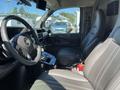 Interior view of a 2013 Chevrolet Express showing the driver's seat dashboard and controls with gray leather seating and a mounted display screen