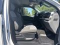 Interior view of a 2023 Ford F-350 SD showing the driver's side seat and dashboard in gray fabric with a spacious cabin design