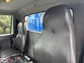 The image shows the interior of a 2013 International DuraStar 4300 with two large seats and a dashboard featuring various controls and buttons