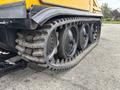 A close-up view of the caterpillar track of a 2004 Bombardier SW48 showing large rubber treads and wheels designed for off-road traction