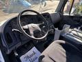 Interior view of a 2006 Freightliner M2 106 showing the steering wheel dashboard and driver's seat with a "Thank You" mat on the floor