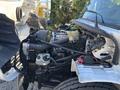 A 2005 Freightliner M2 106 engine compartment featuring an exposed engine with various components including hoses, filters, and a battery