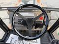 Overhead view of a 2005 Case 570 tractor steering wheel with control panel and pedals visible